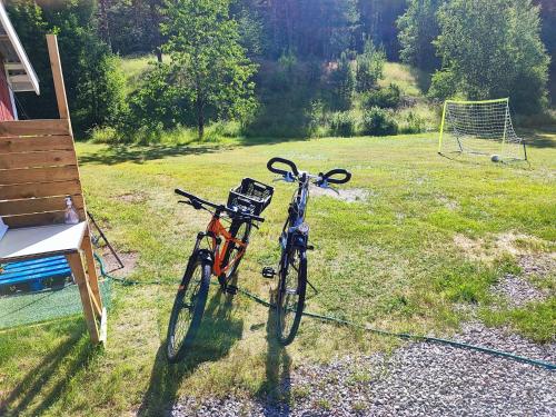 two bikes parked next to each other in a field at Bie huset 