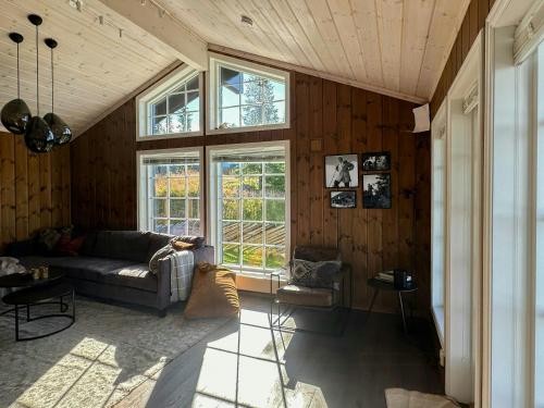 a living room with a couch and a window at Mountain Cabin With Panoramic Views In Sjusjøen in Sjusjøen