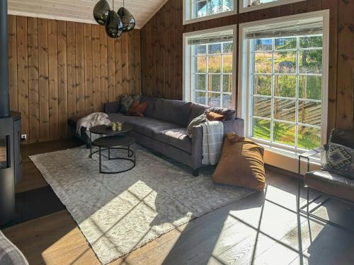 a living room with a couch and a table at Mountain Cabin With Panoramic Views In Sjusjøen in Sjusjøen