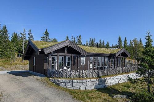 a house with a grass roof on a road at Mountain Cabin With Panoramic Views In Sjusjøen in Sjusjøen