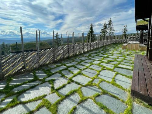 a patio with a fence and grass at Mountain Cabin With Panoramic Views In Sjusjøen in Sjusjøen