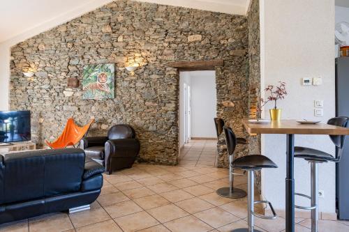 una sala de estar con una pared de piedra en gite de la Mabonniere, en Oudon