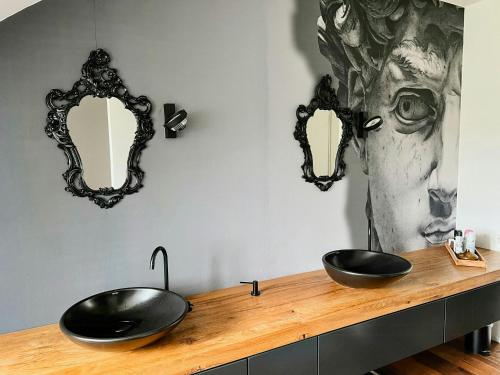 a bathroom with two sinks on a wooden counter with mirrors at Renovated Farmhouse Half In The Trierer Heide in Trier