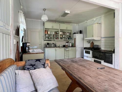 a living room with a wooden table and a kitchen at Cultural Cottage By Lake Fryken In Värmland in Östra Ämtervik