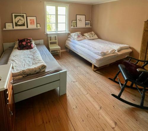 a bedroom with two beds and a desk and a chair at Cultural Cottage By Lake Fryken In Värmland in Östra Ämtervik