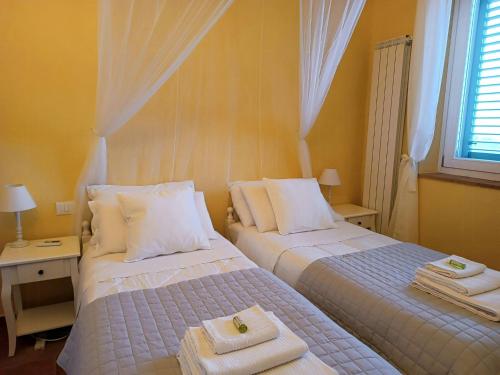 two beds in a bedroom with towels on them at Tuscan Villa With Sea View And Jacuzzi in Fosdinovo