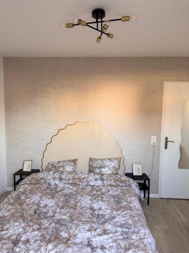 ブゾンにあるAppartement moderne proche La Défenseの大きなヘッドボード付きの大きなベッドのある寝室