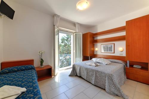 a hotel room with a bed and a window at Hotel Taormina in Riccione
