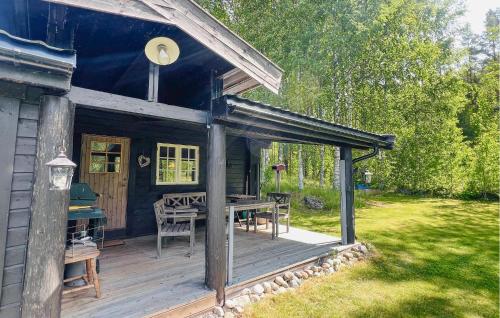 a cabin with a wooden deck with a table and chairs at 2 Bedroom Awesome Home In Östmark in Östmark