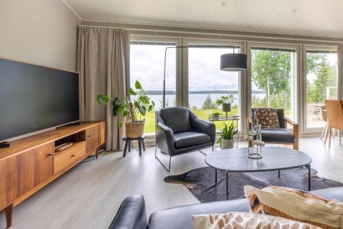 Una sala de estar con un televisor y una mesa y sillas. en Villa Vilkama, en Laukaa
