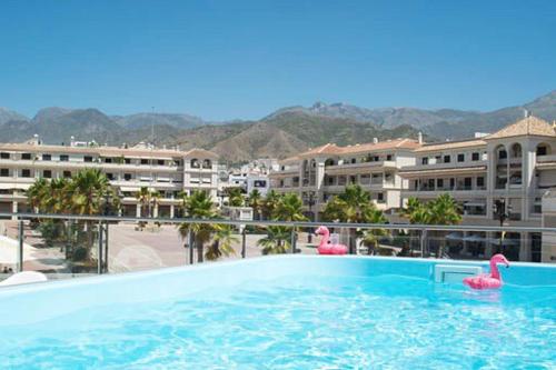 a swimming pool with pink flamingos in a building at Edificio Resort Gran8Nerja in Nerja