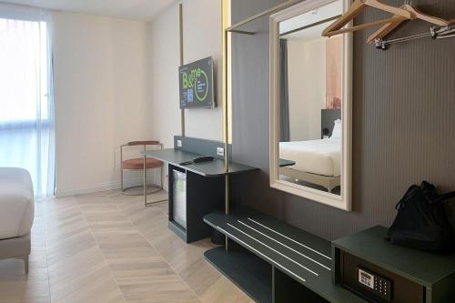 a hotel room with a mirror and a bed at B&B HOTEL Venezia Laguna in Venice