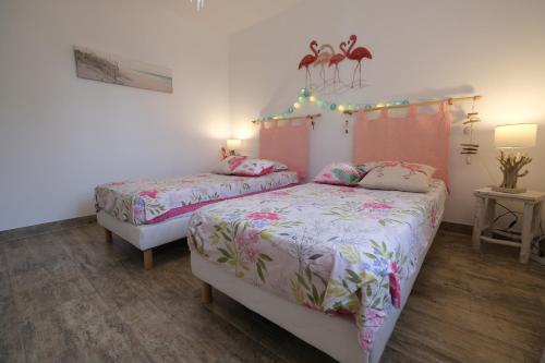 a bedroom with two beds and a table with lights at A pretty family house located in a tranquil area with a pretty view of the Luberon range. in Les Taillades