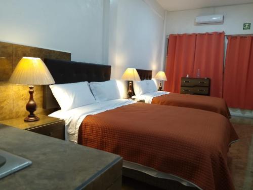 a hotel room with two beds and two lamps at Gran Tonantzin in San Martín de las Pirámides