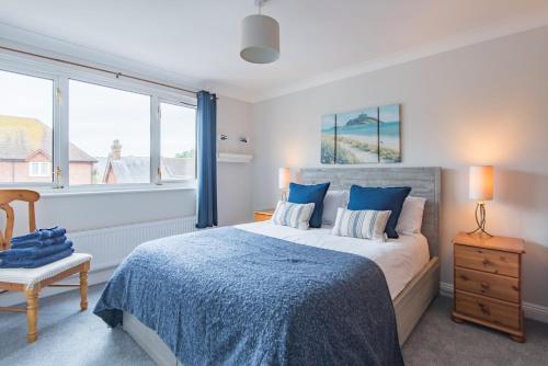 a bedroom with a bed and a chair and windows at The Landing in Hythe