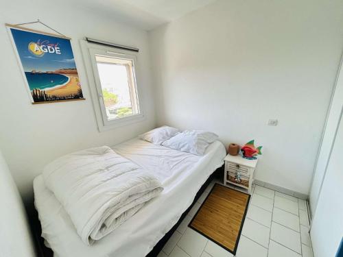 une petite chambre avec un lit et une fenêtre dans l'établissement Appt 2 pièces 4 couchages CAP D'AGDE CT045-2911, au Cap d'Agde
