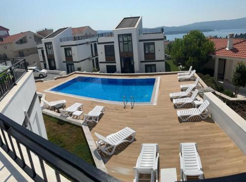 Tivat Terrace Deluxe في تيفات: مسبح مع كراسي جلوس الكراسي ومسبح