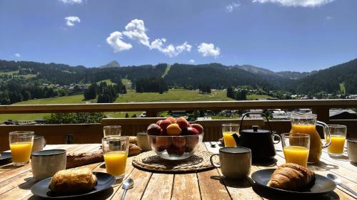 a table with a bowl of fruit and a bowl of bread at Duplex Pen Men - LES GETS, proche du centre, jacuzzi, superbe vue in Les Gets
