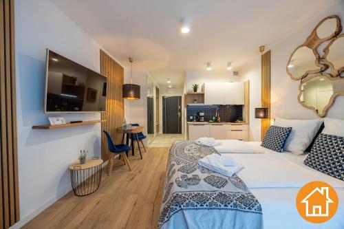 a hotel room with a bed and a tv at Apartamenty ApartPark - visitopl in Świnoujście