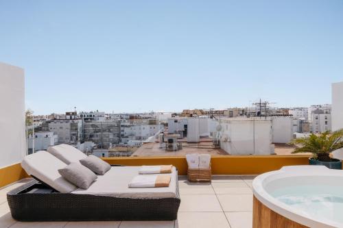 a balcony with a tub and a view of a city at Hotel Colón Gran Meliá - The Leading Hotels of the World in Seville