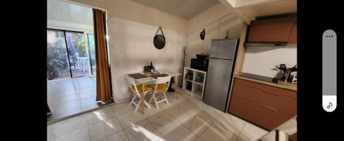 une petite cuisine avec une table et un réfrigérateur dans l'établissement maisonnette de vacances proche plage, à Borgo