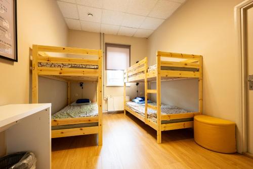 two bunk beds in a room with wooden floors at Tamme staadioni hostel in Tartu