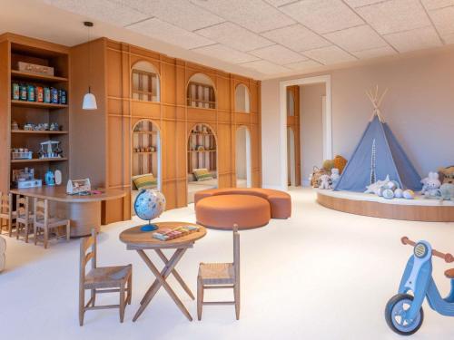 a living room with a table and chairs and a couch at Fairmont La Hacienda Costa del Sol in Alcaidesa
