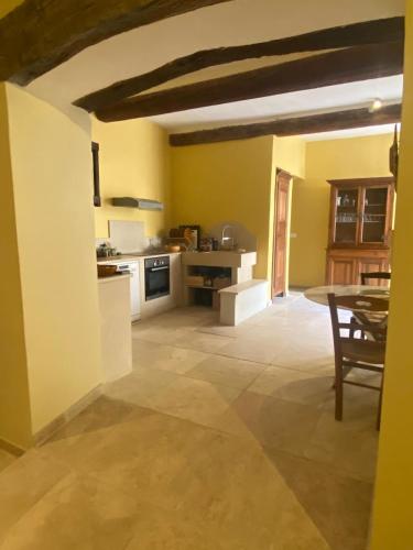 une cuisine avec des murs jaunes et une table. dans l'établissement Spa Roquemaure, à Roquemaure