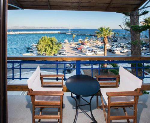 a balcony with chairs and a view of a marina at Thalassa Suites a la mer in Agia Galini