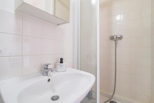 a white bathroom with a sink and a shower at Studio zen JD54#1 in Reims