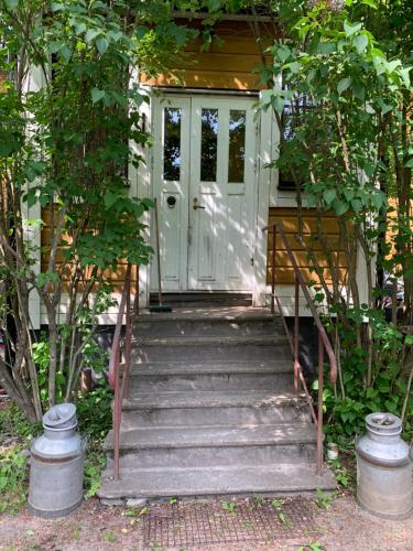 a house with stairs leading to a door at A Lovely House with A Garden in Helsinki in Siltamäki