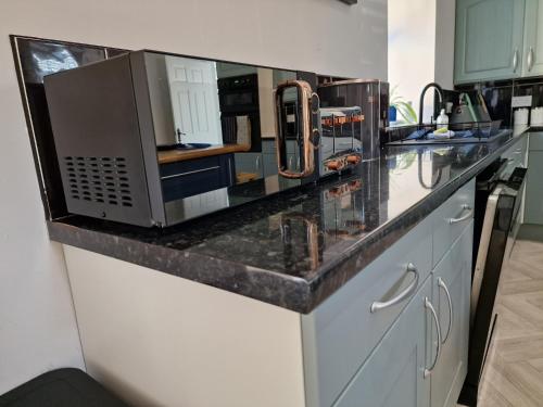 a kitchen counter with a microwave on top of it at Southbarn - Spectacular Country Home in Winestead