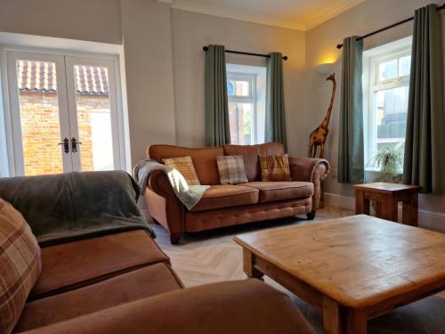 a living room with a couch and a coffee table at Southbarn - Spectacular Country Home in Winestead