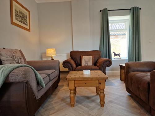 a living room with a couch and chairs and a table at Southbarn - Spectacular Country Home in Winestead