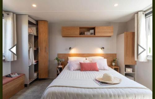 - une chambre dotée d'un grand lit avec deux chapeaux dans l'établissement Mobilhome confortable, spacieux et lumineux dans camping, aux Mathes
