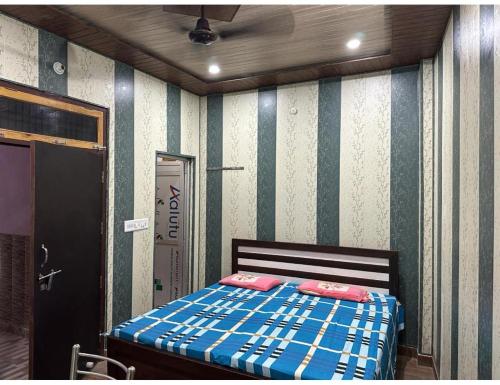 a bedroom with a bed and a striped wall at SLH guest house in Faizābād