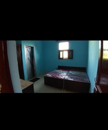 a bedroom with a bed in a blue room at Harjas homestay in Kharar