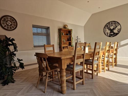 a dining room with a wooden table and chairs at Southbarn - Spectacular Country Home in Winestead