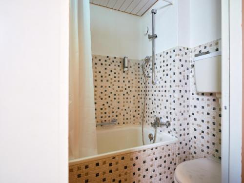 a bathroom with a bath tub and a toilet at Löwen Lodge in Seelisberg