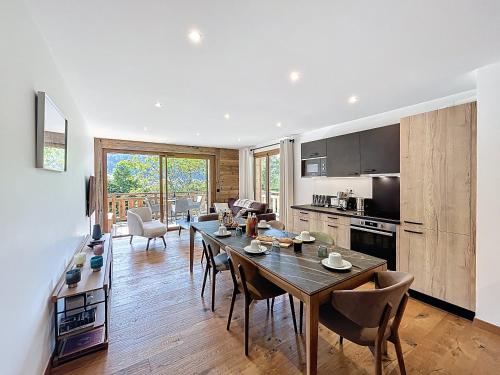 une cuisine et une salle à manger avec une table et des chaises dans l'établissement Tamaris - Morzine - secteur Planet, à Morzine