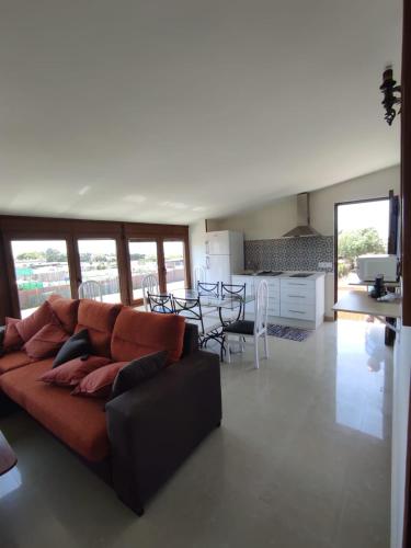 a living room with a brown couch and a kitchen at La Buena Vida, el Palmar in El Palmar