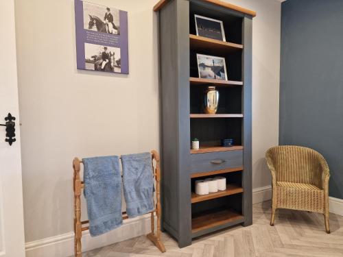 a book shelf in a room with a chair at Southbarn - Spectacular Country Home in Winestead