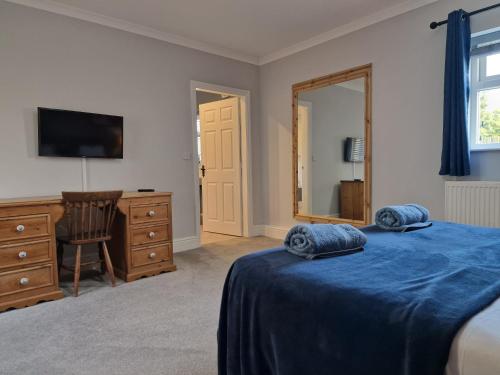 a bedroom with a bed and a dresser and a television at Southbarn - Spectacular Country Home in Winestead