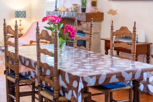 a dining room table with a vase of flowers on it at Villa Nicole face mer in Trégunc