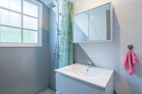 a white bathroom with a sink and a mirror at Villa Nicole face mer in Trégunc