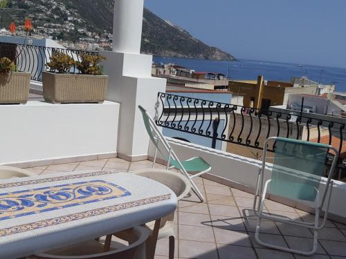 a patio with a table and chairs on a balcony at Baia Unci in Canneto