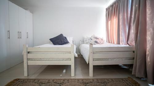 two twin beds in a room with a window at Castelo Beach Resort in Inhambane