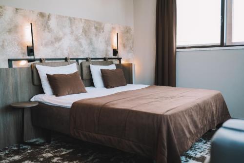 a bedroom with a large bed with two pillows at Old Mill Hotel in Klaipėda