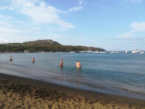 a group of people in the water at the beach at casa giardino in Vulcano