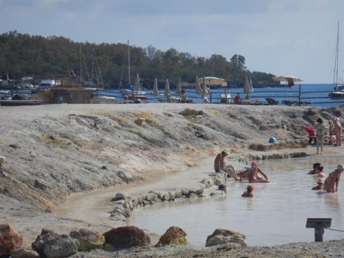 a group of people in the water on a beach at casa giardino in Vulcano